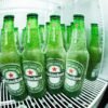 Frosted Heineken beer bottles in a refrigerator showcasing the refreshing coolness.